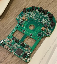 The micromouse's green printed circuit board, shaped to the chassis outline